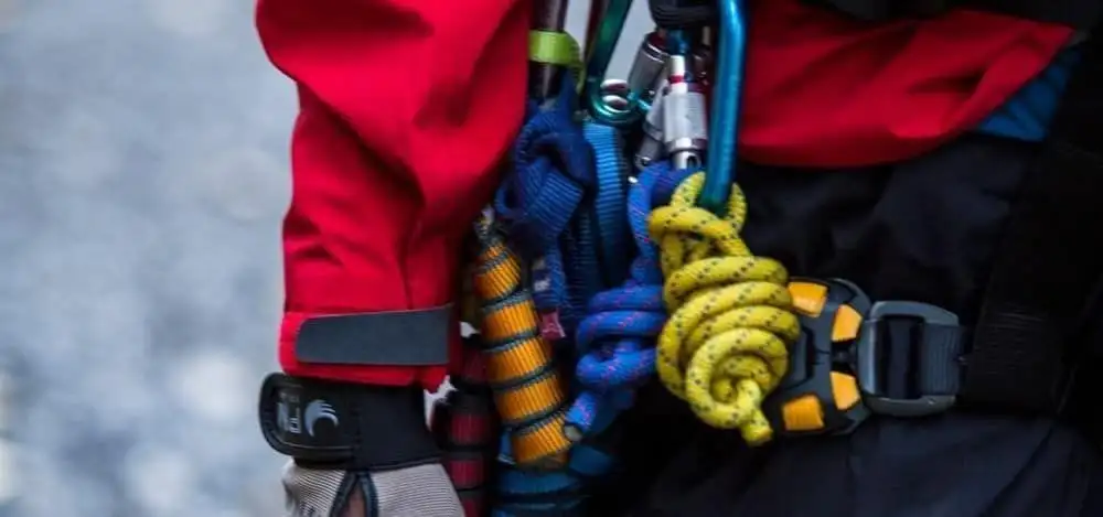 A rescuer descending a rock face on ropes during training