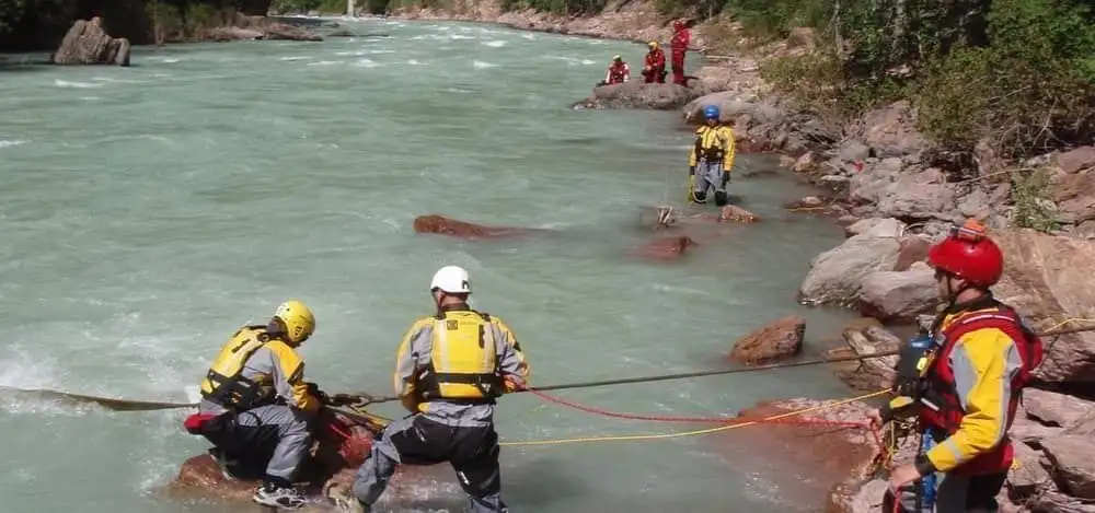 Swiftwater technicians working a rescue craft in moving water